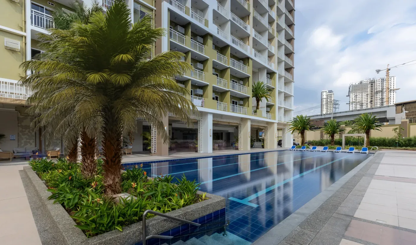 The lap pool at The Celandine, edged with planting and palms below the residential floors