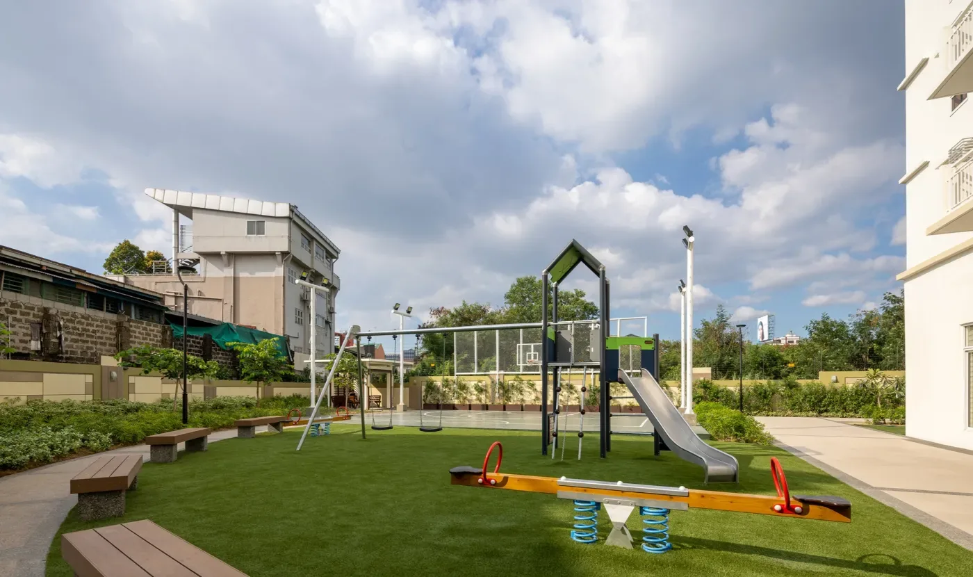 The children's playground at The Celandine with swings, a slide and open lawn