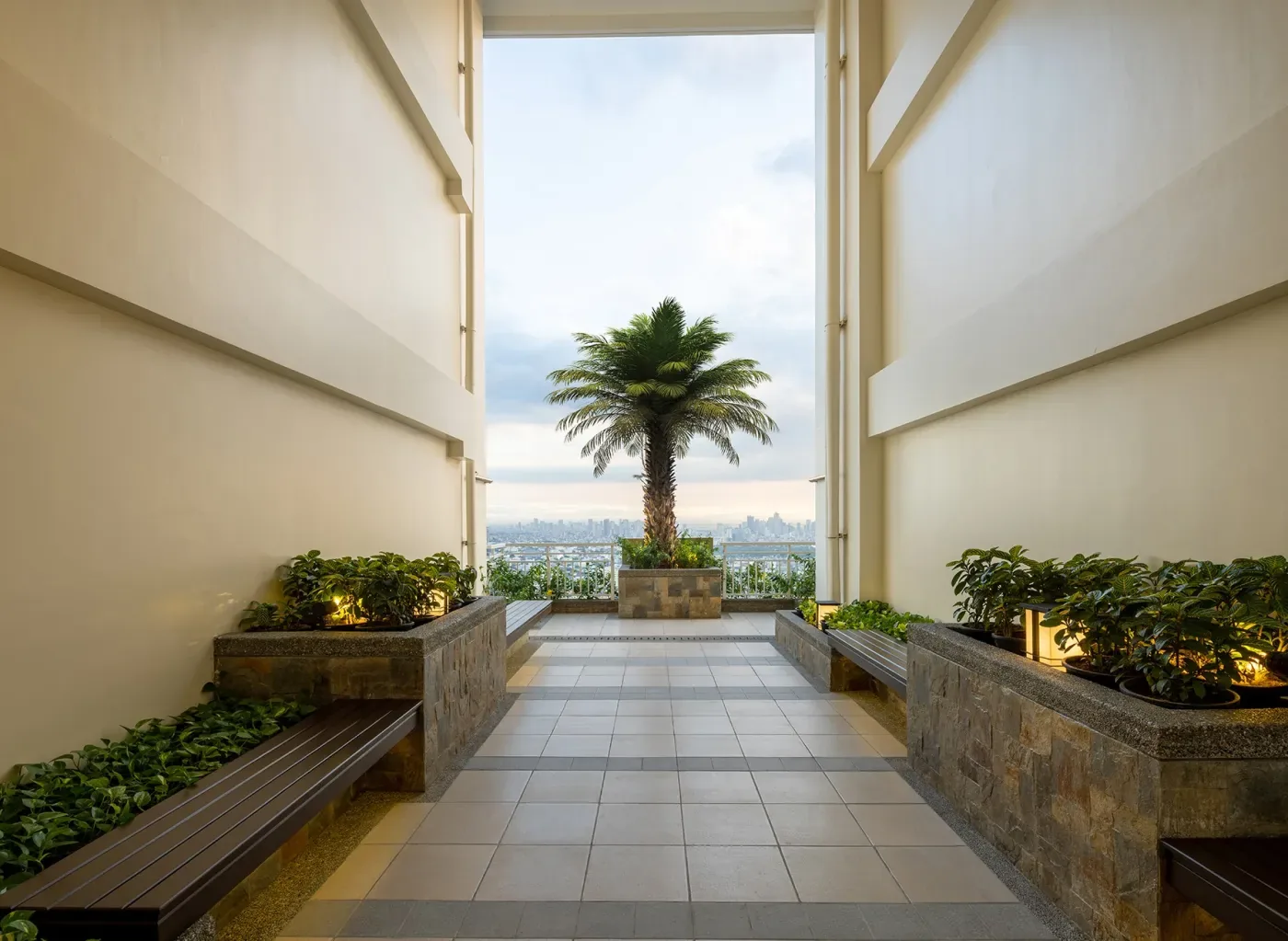 A Lumiventt Sky Patio at The Celandine, an open-air breezeway with planting and a view over the city