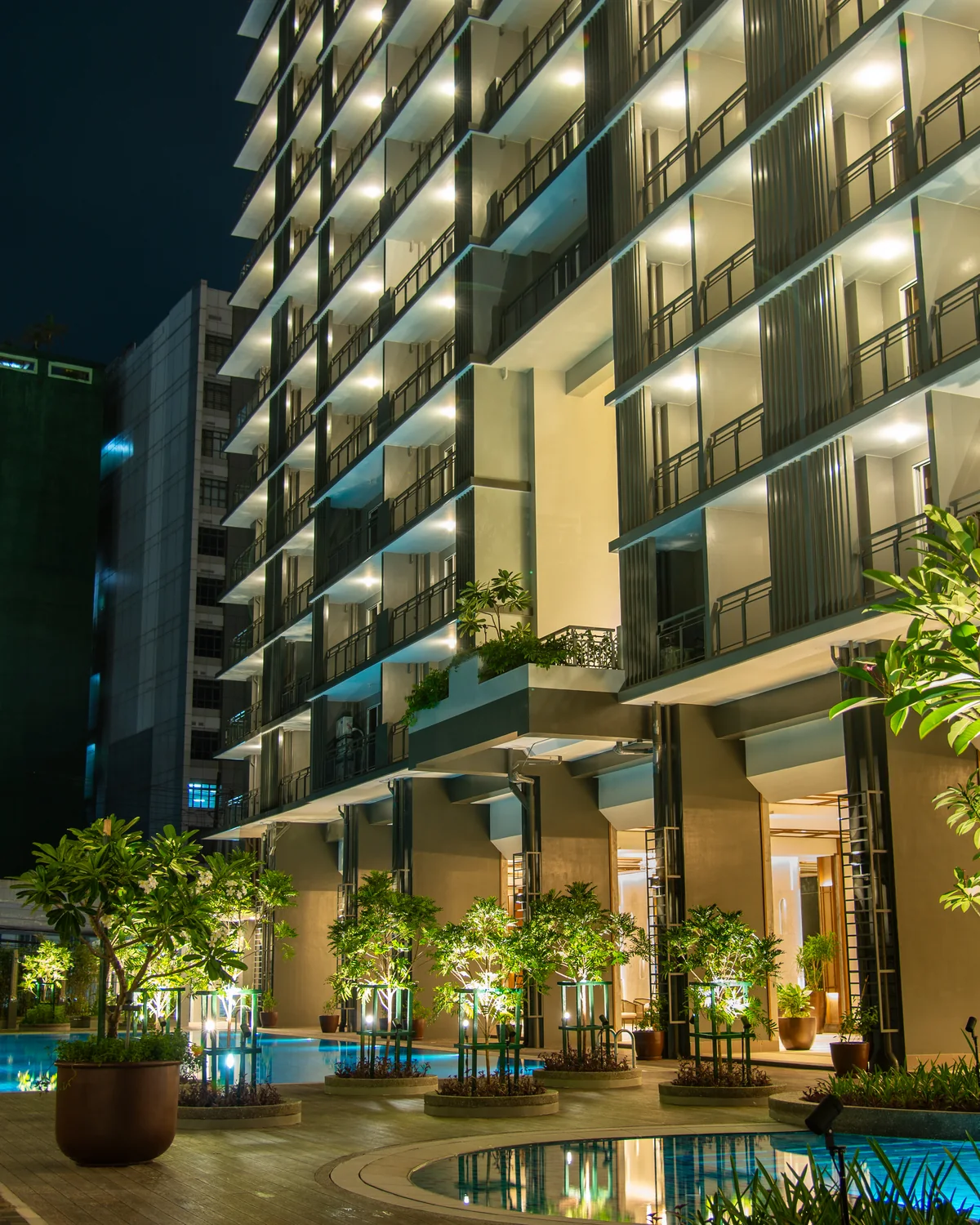 The Oriana North Tower rising over the lap pool at night, Quezon City