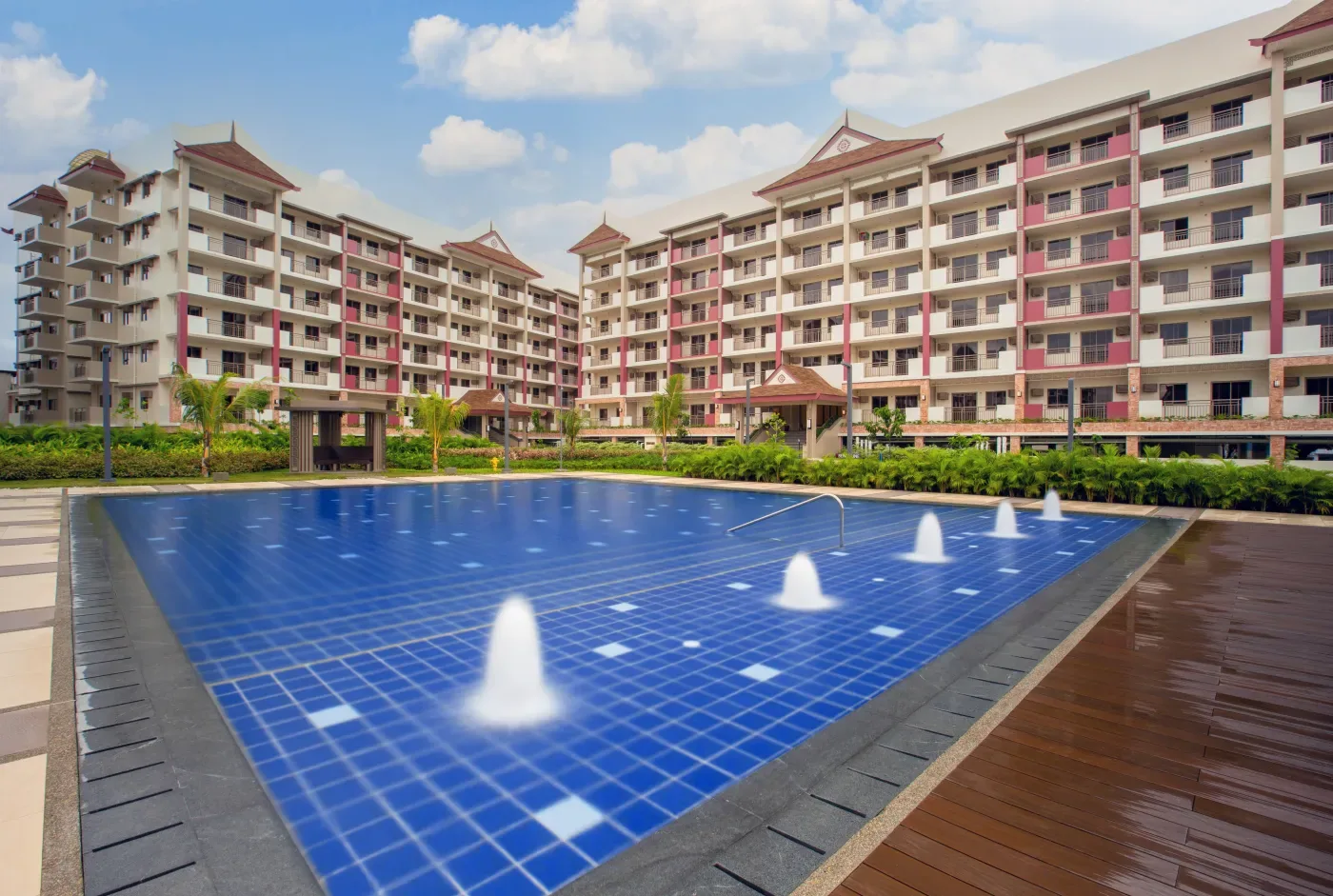 Pool deck with fountain jets at Mulberry Place, mid-rise buildings behind
